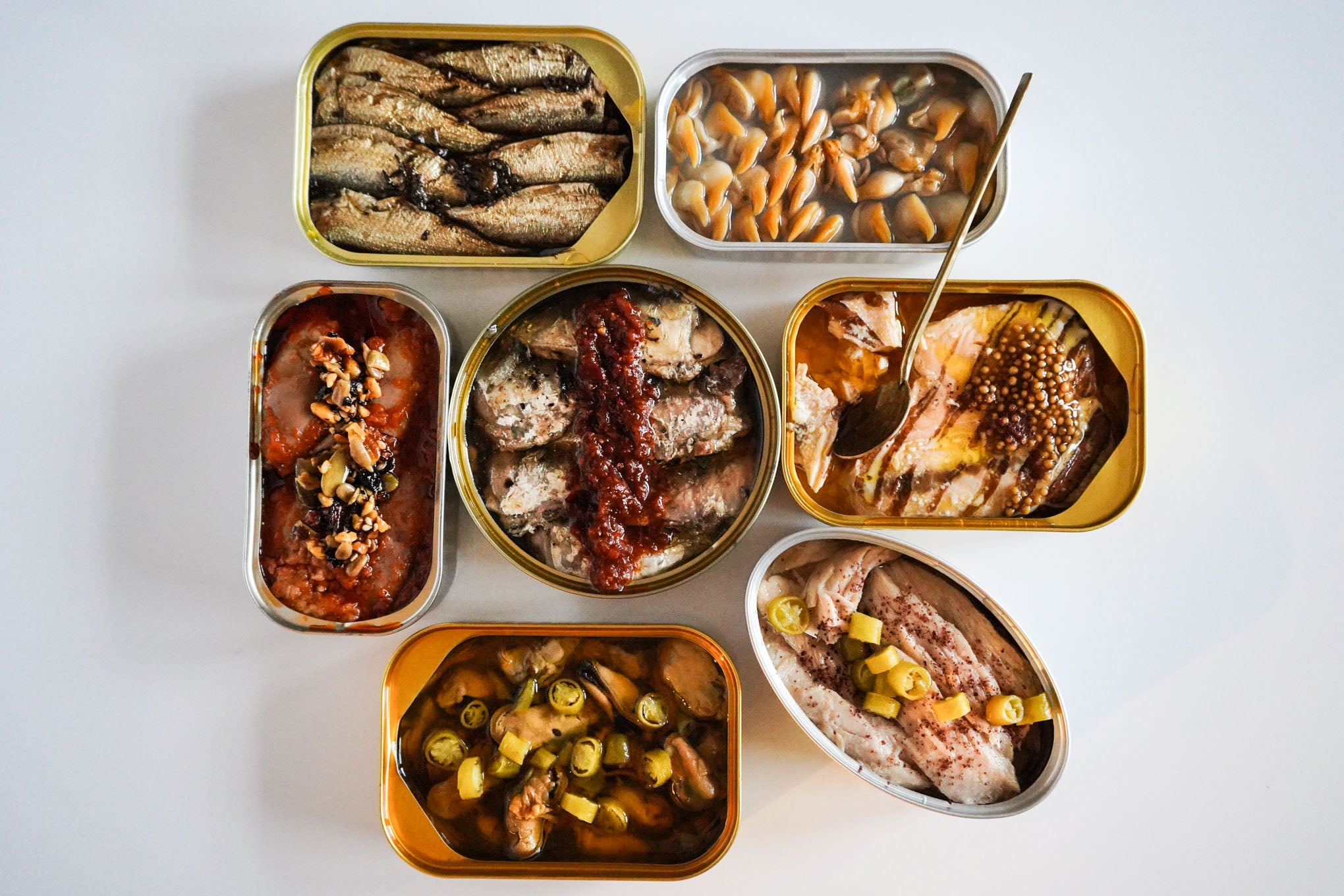 open tinned fish cans with yuzu kosho, pickled mustard seeds and guindilla peppers