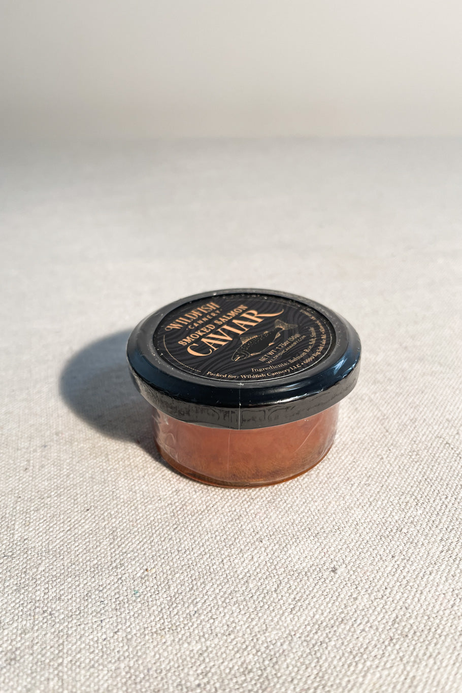 Jar of smoked salmon caviar on white background