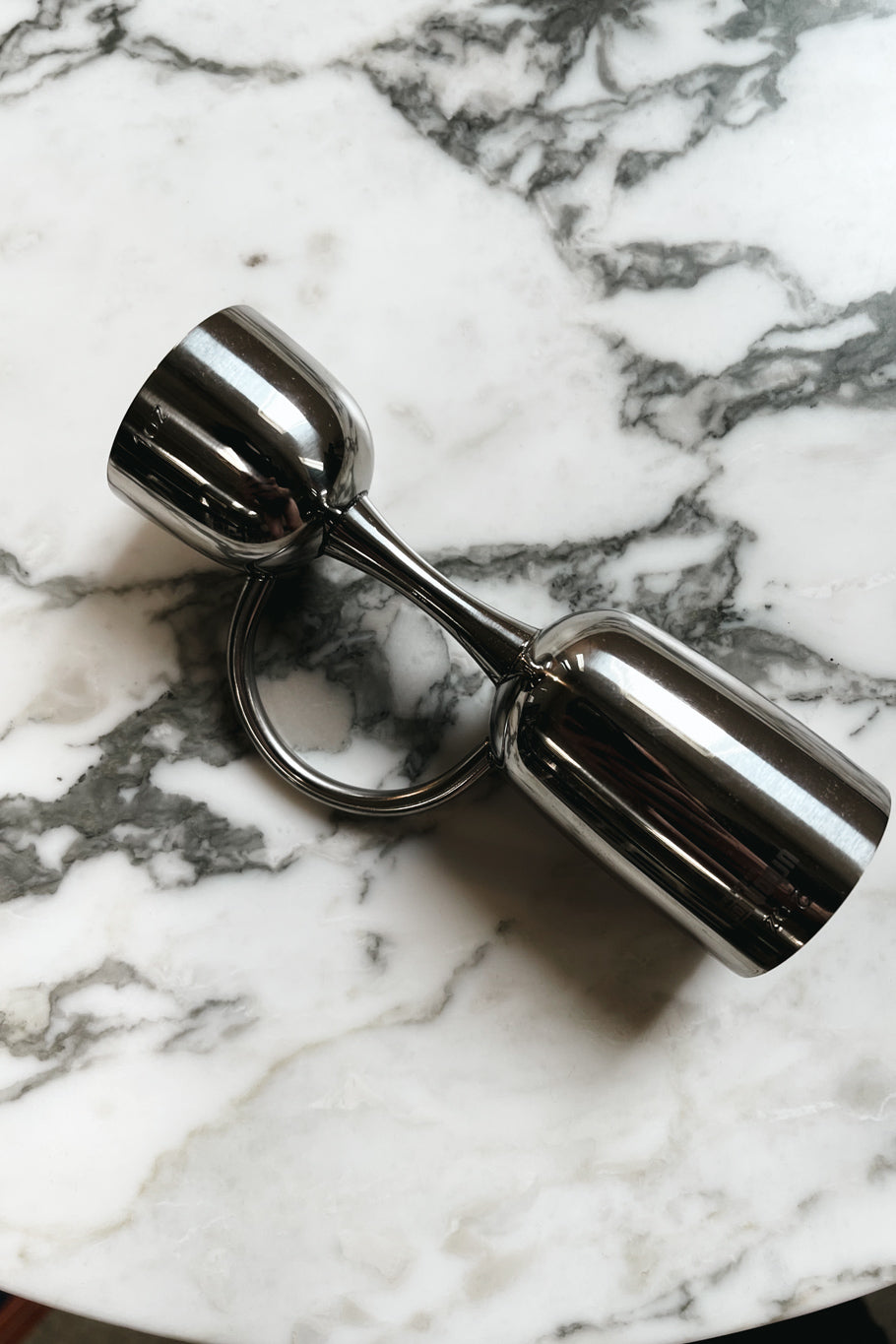 polished silver coley jigger on marble table